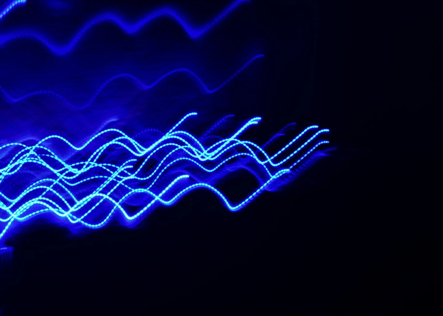 Linee blu elettrico ondulate attraversano uno sfondo nero scuro.